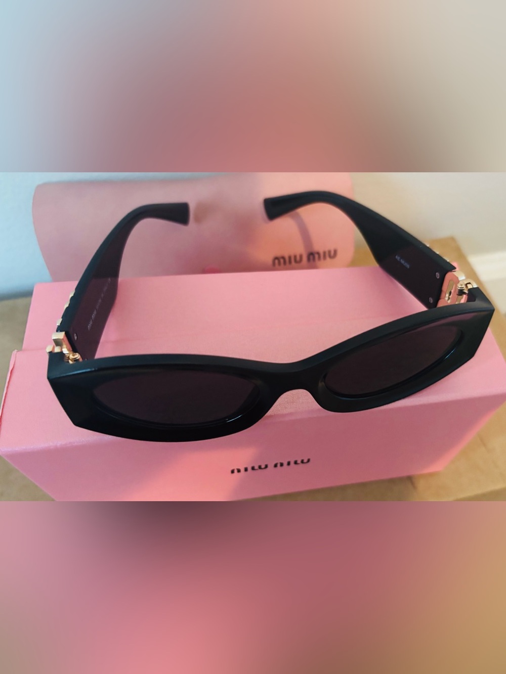 Miu Miu Black Oval Sunglasses with Gold Accent